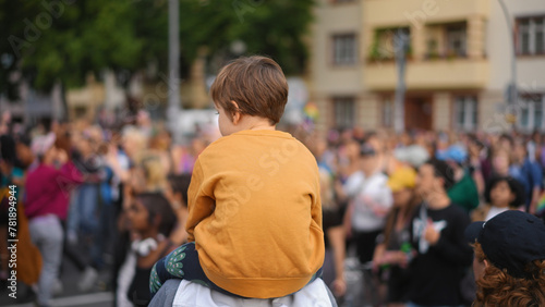 Little kid sit father shoulders. Many gay people crowd protest against homophobia. Family walk lgbt pride parade. Child watch strike demonstration. Parents show csd fest day to boy son. Peaceful rally