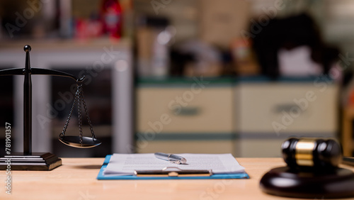 A scale is on a table with a piece of paper and a gavel © Mdisk