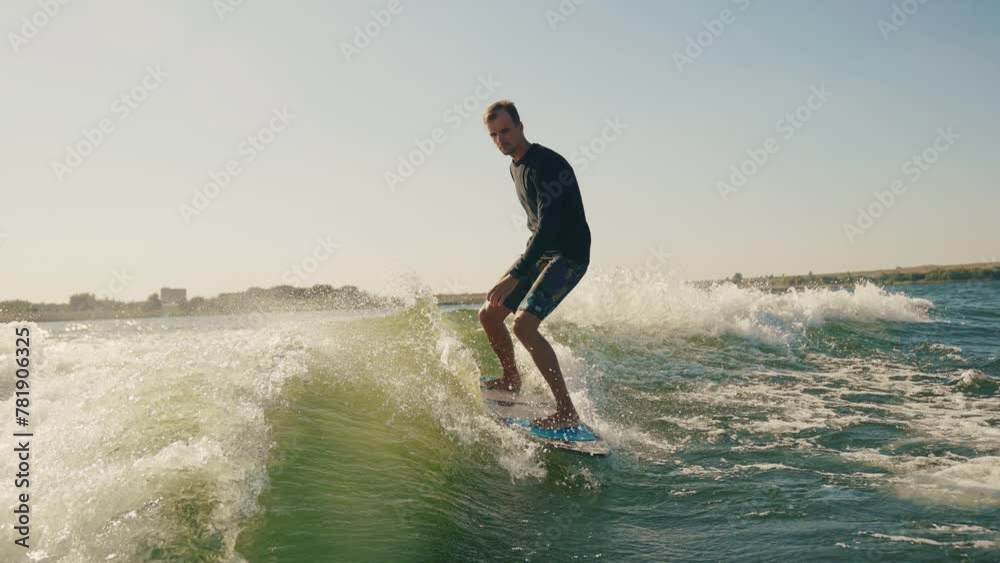 Wakeboarding. A wakeboarder glides on the water behind a boat. Skilled wakeboarding Wakeboarding. A wakeboarder glides on the water behind a boat. Skilled wakeboarding