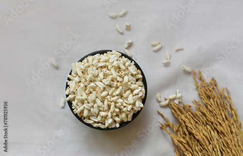 Popped Rice or Nel Pori also known as Puffed Lahi or Karthigai Pori in a wooden bowl on a white background. Low-calorie diet food concept. Selective focus on bowl and food. photo