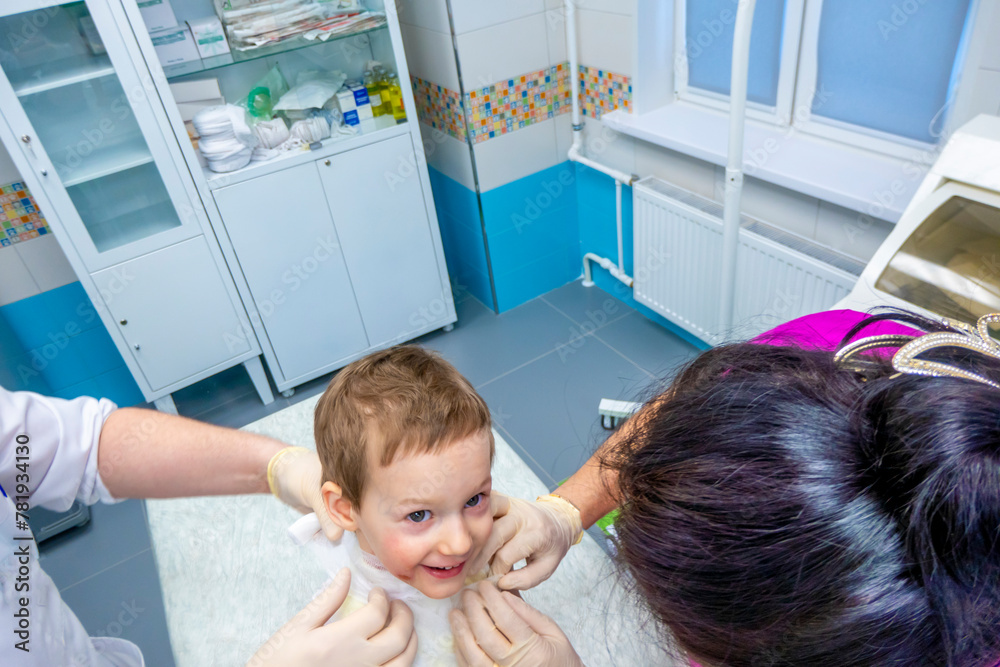 medical procedure dressing a boy with a first-degree burn from boiling water on his face, neck and chest