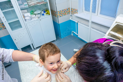 Obraz na płótnie medical procedure dressing a boy with a first-degree burn from boiling water on his face, neck and chest w salonie