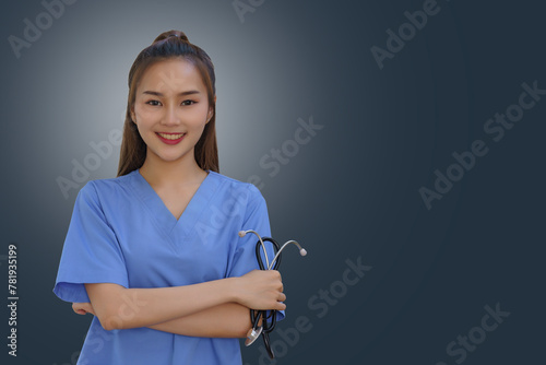 An Asian female doctor is holding a stethoscope on a gray background.