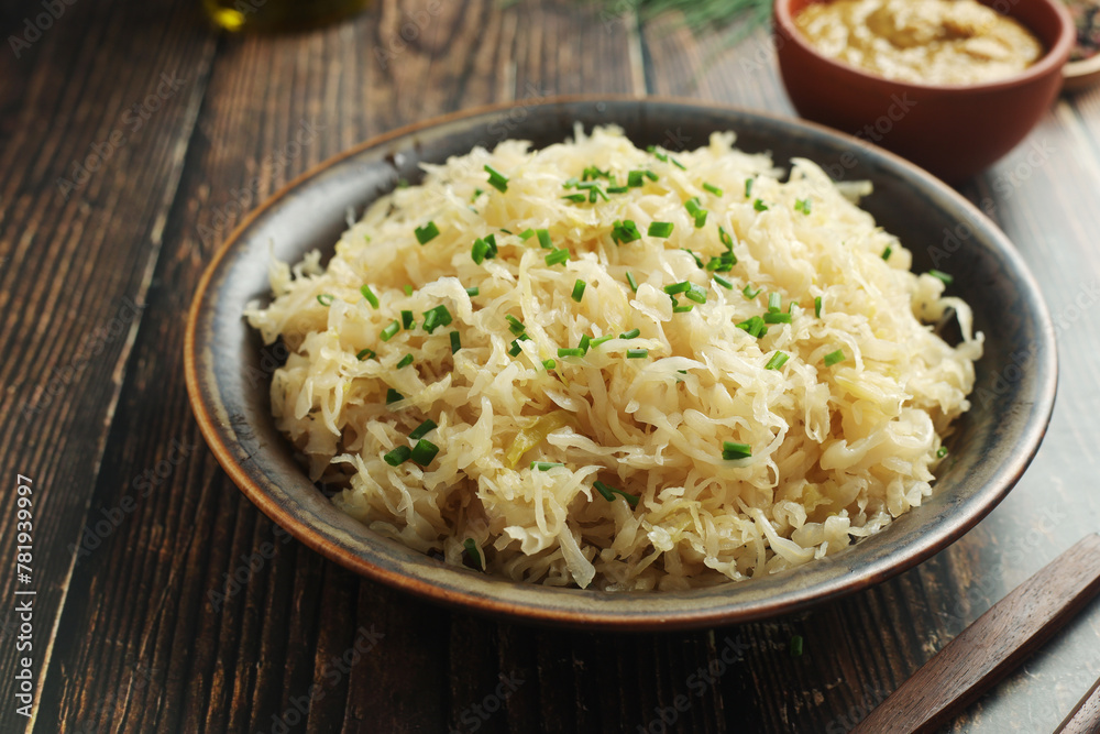 A bowl with traditional German Sauerkraut served in rustic style A bowl with traditional German Sauerkraut served in rustic style