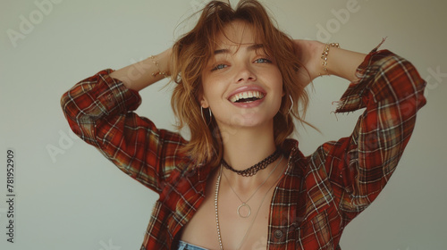 Just happy. Young smiling exited woman in casual wear holding hand on head and shouting while standing against gray studio background. Cheerful crazy girl with open mouth posing to camera.