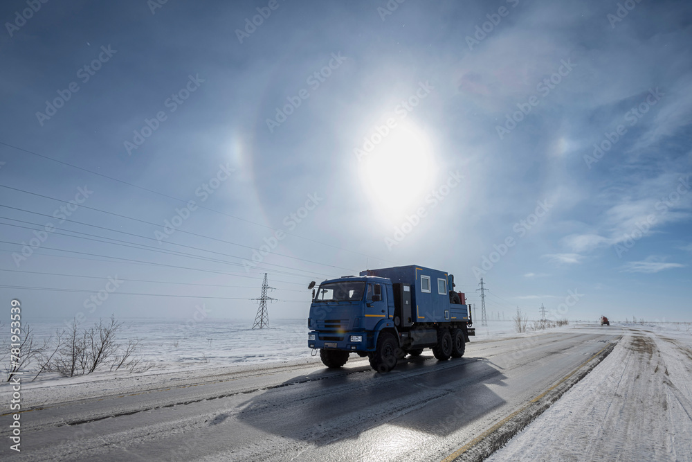 A truck on a winter road with a halo background