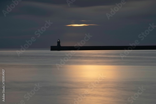 Tranquil view of the South Shields pier and lighthouse at sunrise in Tynemouth, England photo