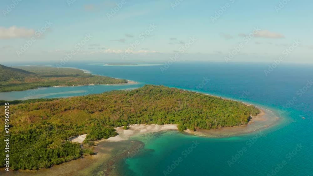 Tropical island Balabac covered with green rain forest against the blue sky with clouds and blue sea from above. Seascape: Ocean and sky. Palawan, Philippines