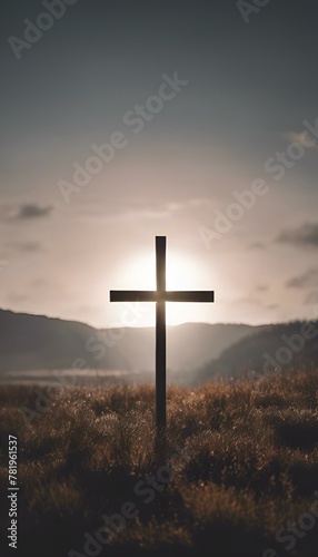 a cross in the background with mountains in the distance and sun behind it