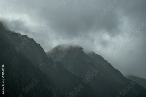 Low angle shot of a mountainside covered in mist in gloomy weather
