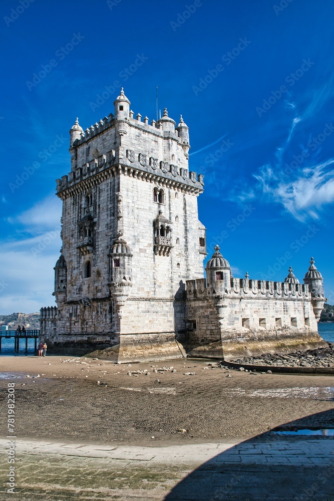Belem Tower by the sea on a sunny day, Lisbon, Portugal, vertical