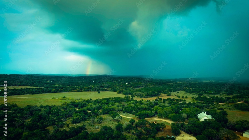 Fototapeta premium Aerial shot of trees on a field under a cloudy stormy sky