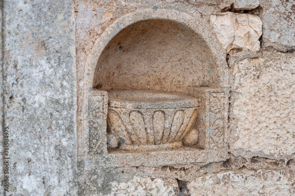 Close-up shot of an ancient engraving of a vase in a stone wall