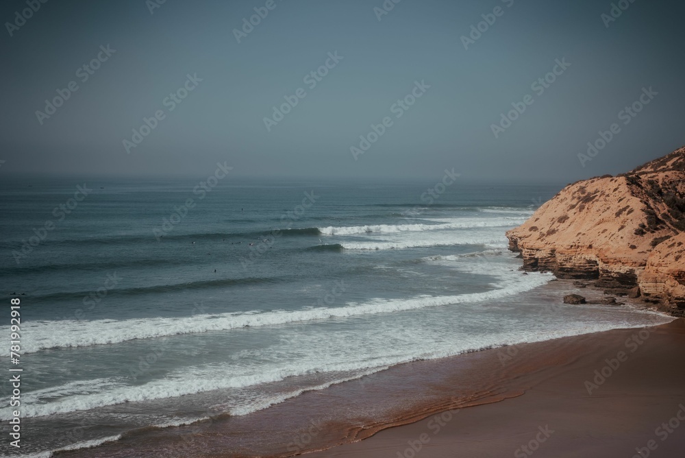 Beautiful shot of ocean waves covering a sandy beach