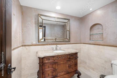 Compact bathroom with a spacious mirror over the sink in Encino, California