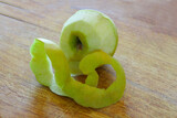 Peeled green apple on a wooden table..