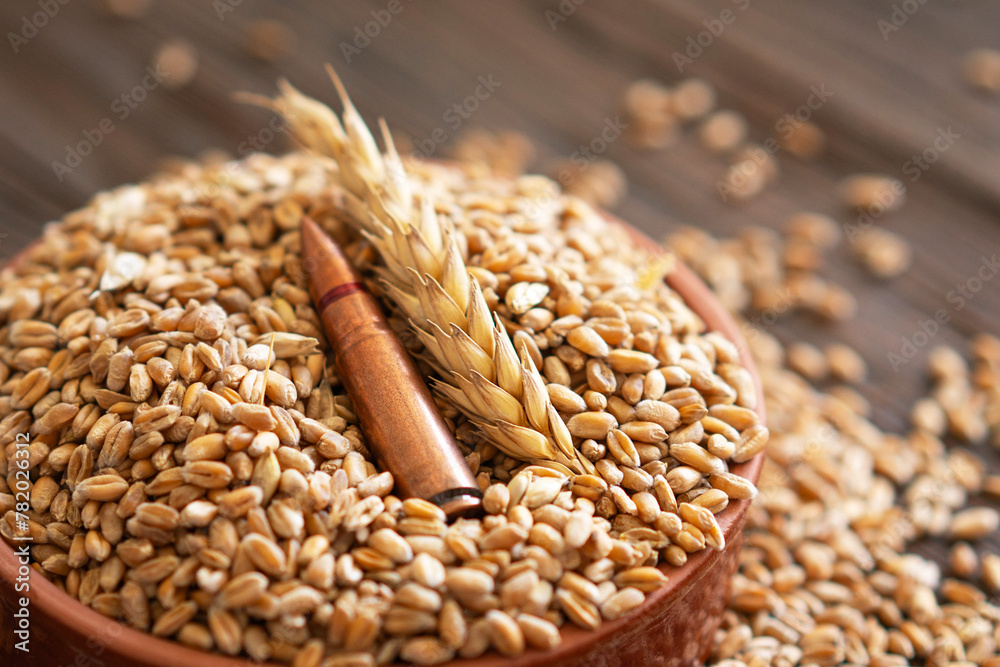 Obraz premium Scattered Wheat Grains and Bullet Shells on a Wooden Surface
