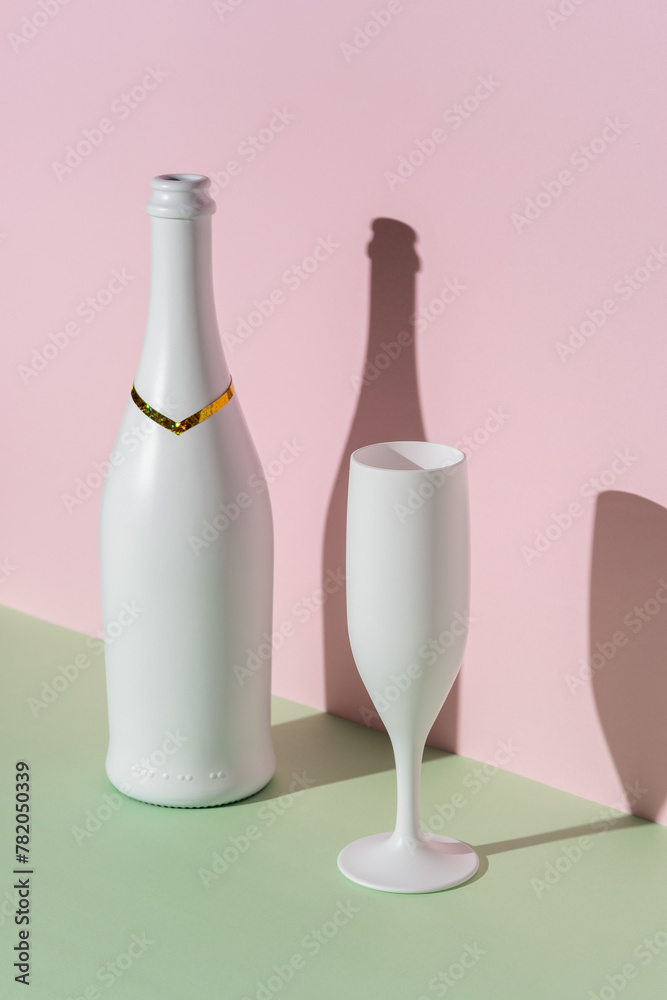 White champagne bottle and champagne glass on bright background.. Minimal party concept. White champagne bottle and champagne glass on bright background.. Minimal party concept.