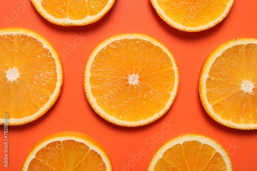 Slices of juicy orange on terracotta background, flat lay