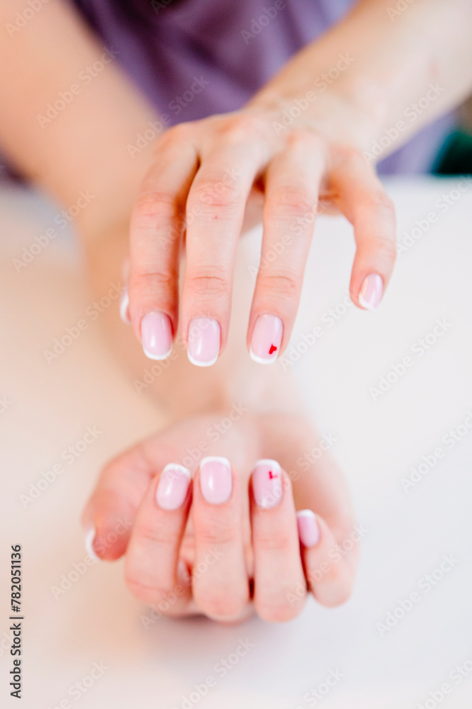 The woman's hands seem to be holding something. Ready to help or accept. Gesture isolated on white background. A helping hand is stretched out to save. Decorated with a French manicure.