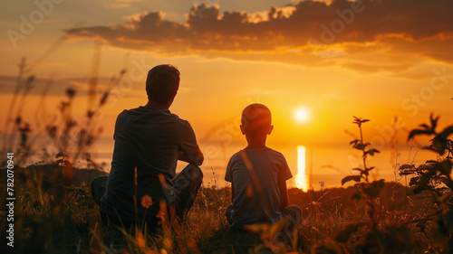 A father and son watching the sunset together, sharing a moment of tranquility and bonding amidst the beauty of nature.
