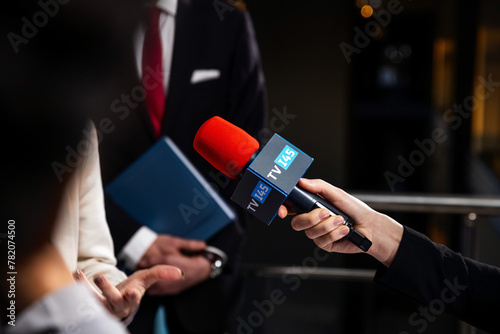 Political speech of EU consul during press campaign. Confident female European politician answers journalists questions, gives interview for media and television news in European Parliament building.