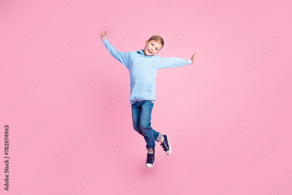 Full length photo of excited energetic schoolkid jump rejoice empty space isolated on pink color background