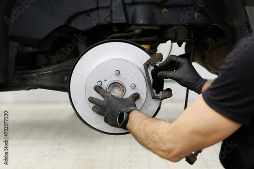 Car disc brake in process of assembly and repair caliper maintenance by mechanic hand