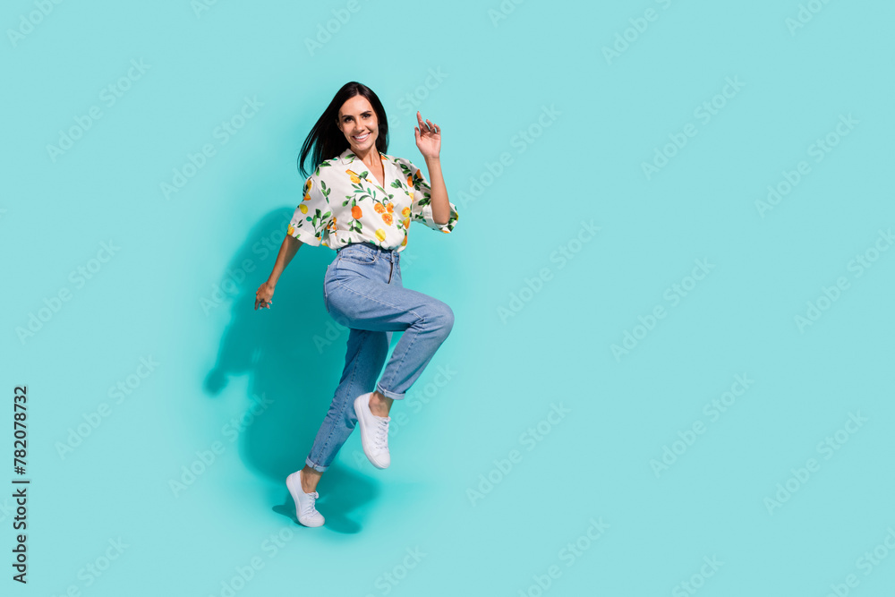 Full length photo of cheerful funky girl wear comfort clothes hurrying mall center running empty space isolated on cyan color background