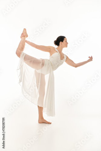 A young woman in a flowing white dress gracefully balances against a clean white background.