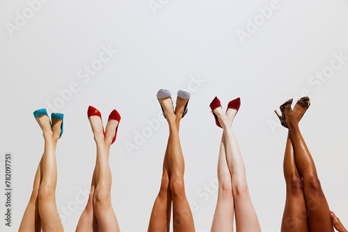Cropped photo of slim female legs with different skin tones in different stylish high heels against white studio background. Concept of beauty, spa procedures, cosmetology, dieting. Ad