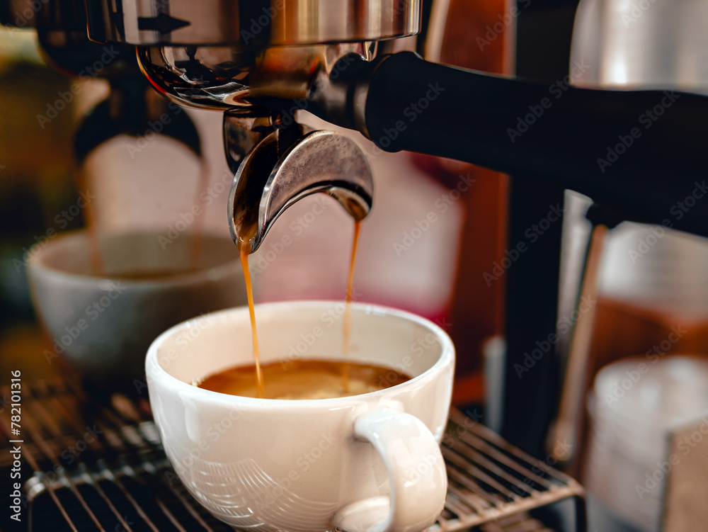 Close-up of espresso pouring from the coffee machine into a coffee cup. Professional coffee brewing,coffee crema Close-up of espresso pouring from the coffee machine into a coffee cup. Professional coffee brewing,coffee crema