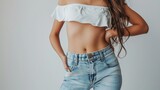 Cropped shot of young tanned slender woman in denim shorts with toned stomach with abs isolated on a white background. Result of fitness, diet, healthy lifestyle. Female belly after a lot of training