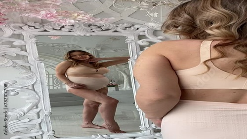 Beautiful pregnant woman in special beige pregnancy underwear. Advertisement of comfortable basic pregnancy underpants. Happy blond girl show her panties in room with flowers. Caucausian woman stand