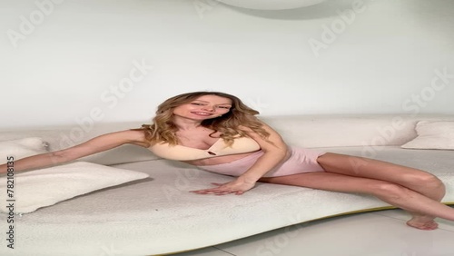 Beautiful pregnant woman in special beige pregnancy underwear. Advertisement of comfortable basic pregnancy underpants. Happy blond girl show her panties in room with flowers. Caucausian woman stand