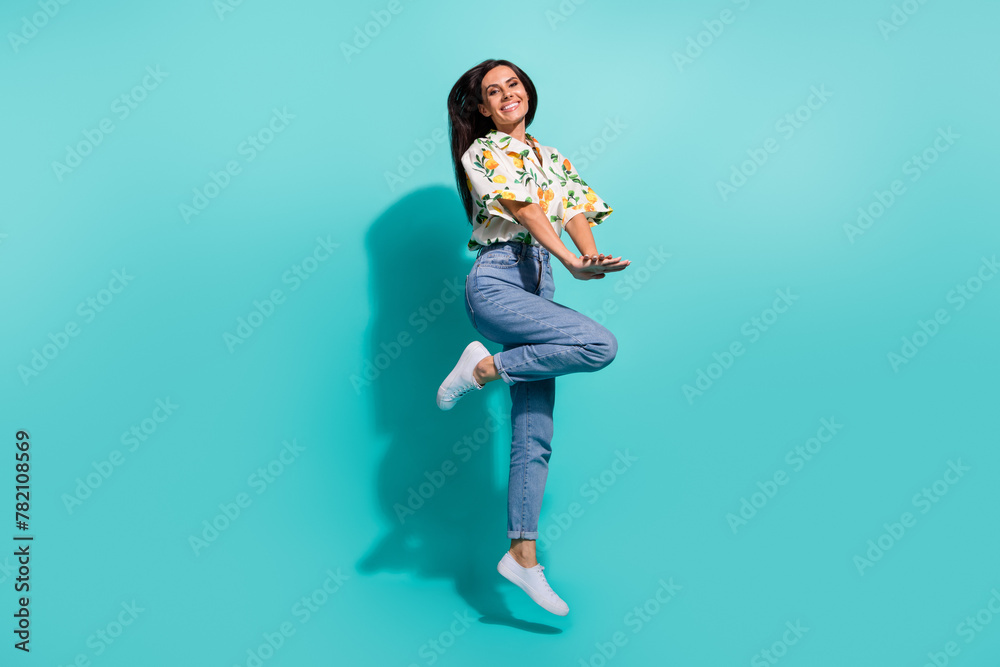 Photo of positive optimistic funky girl wear stylish clothes enjoying summer vacation empty space isolated on cyan color background