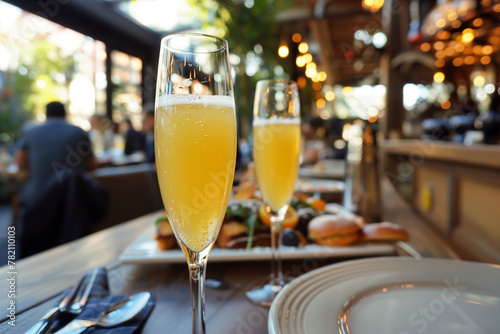 Mimosas served in champagne glasses, amidst a bustling brunch spot in resort. © Degimages