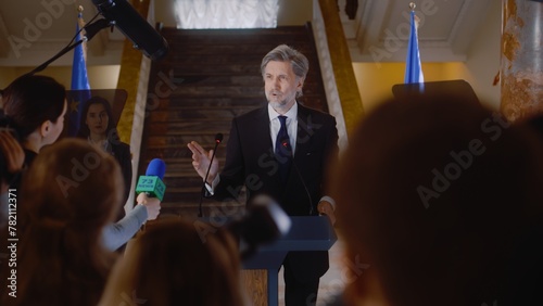 Billede på lærred Mature EU representative comes to press conference and gives interview for social media or TV news in government building hall
