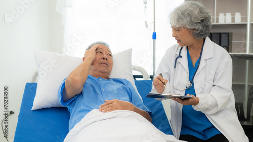Senior Asian female doctor examining a sick old man in bed  female therapist caring for grandfather in nursing home Health care and health insurance