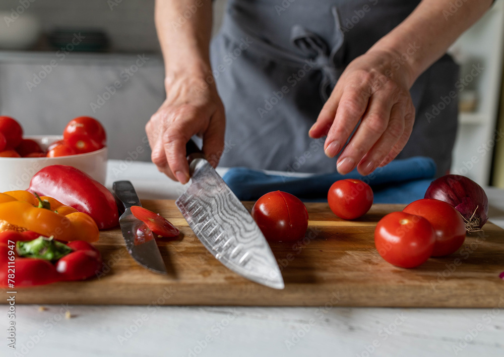 Woman with apron holding a kitchen knife in her hand for cutting vegetables Woman with apron holding a kitchen knife in her hand for cutting vegetables