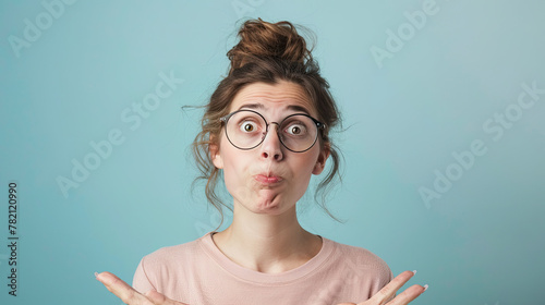 Portrait of a confused puzzled minded woman on pastel blue background photo