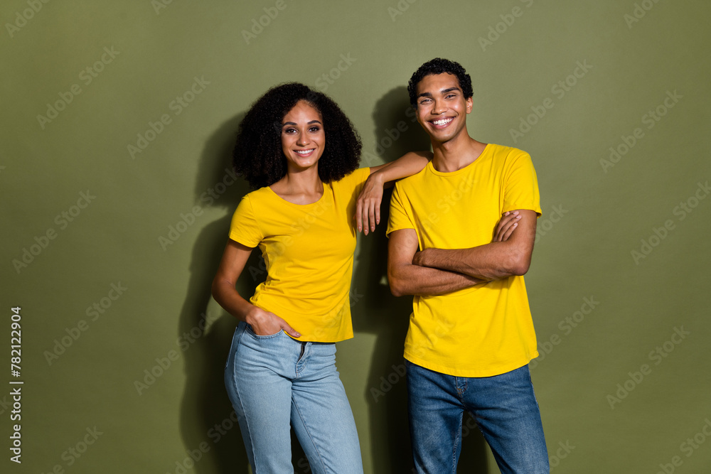 Photo of two young people embrace crossed arms wear t-shirt isolated on khaki color background Photo of two young people embrace crossed arms wear t-shirt isolated on khaki color background