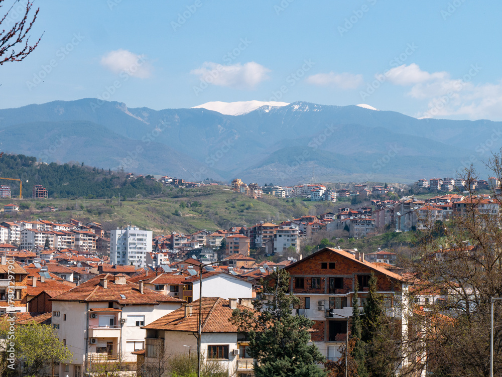 Obraz premium Panorama of Sandanski, Bulgaria on a sunny afternoon with the Pirin Mountains in the backgroud