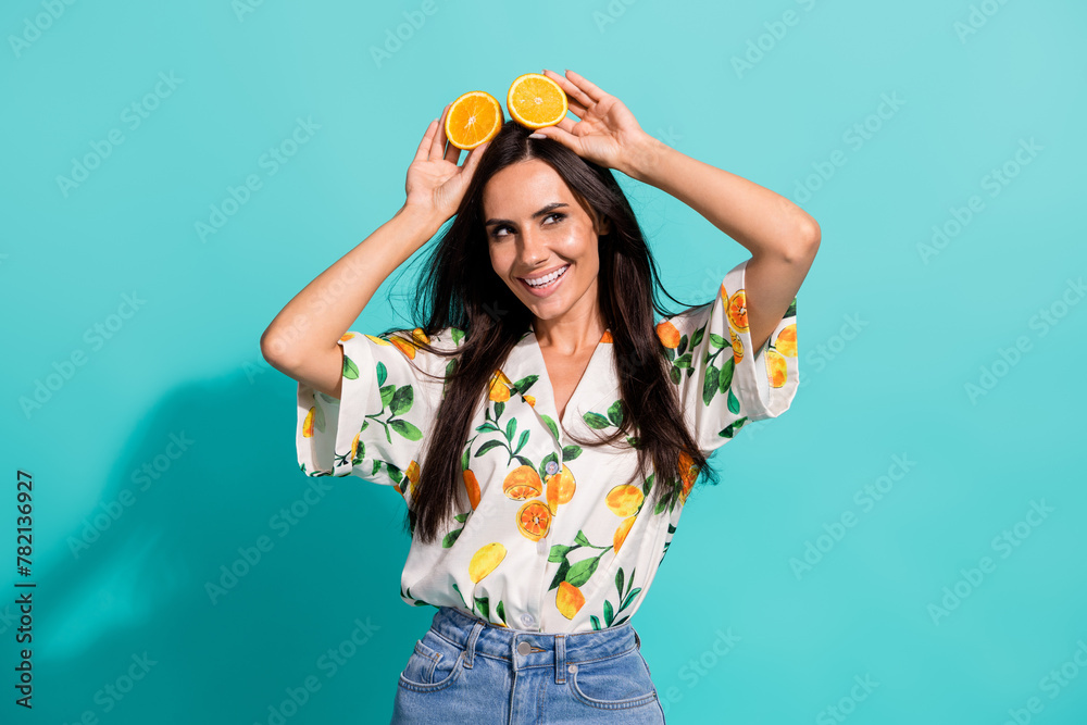 Photo of charming lovely girl wear stylish outfit hands hold juicy mandarin look up empty space isolated on bright cyan color background Photo of charming lovely girl wear stylish outfit hands hold juicy mandarin look up empty space isolated on bright cyan color background