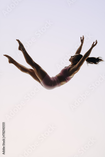 In-flight gymnast: A female acrobatics performer leaps mid-air in a graceful routine © Jacob Lund