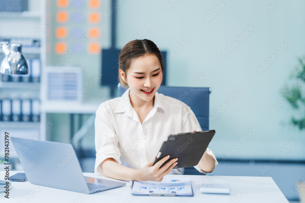 In the office, a businesswoman, accountant by profession, works on financial documents. She uses a computer to calculate income, analyze data, and manage budgets. Asian people. In the office, a businesswoman, accountant by profession, works on financial documents. She uses a computer to calculate income, analyze data, and manage budgets. Asian people.