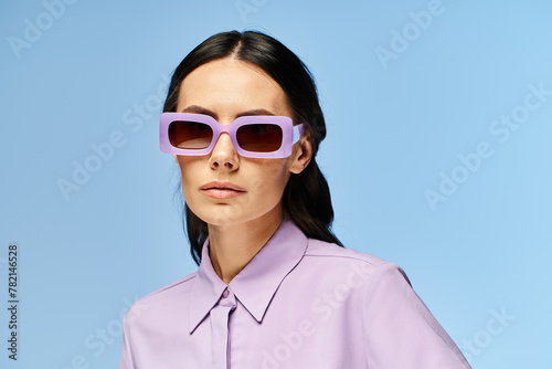 Canvas Print A fashionable woman is enjoying the summer vibes, donning purple attire and trendy sunglasses against a blue studio backdrop