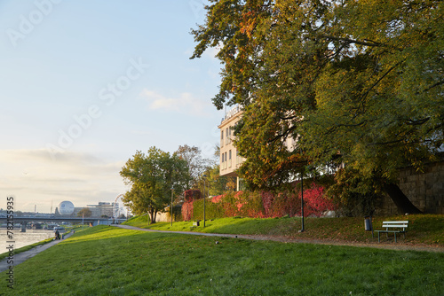 Krakow, Poland. 09.10.2022 Embankment road on the Vistula River at dawn in autumn In the warm rays of the sun.