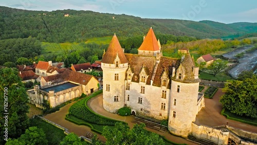 Cinematic stained glass castle with mullioned windows and rooms opening into the valley in France. Aerial view of Fortress at golden sunset in France, photo