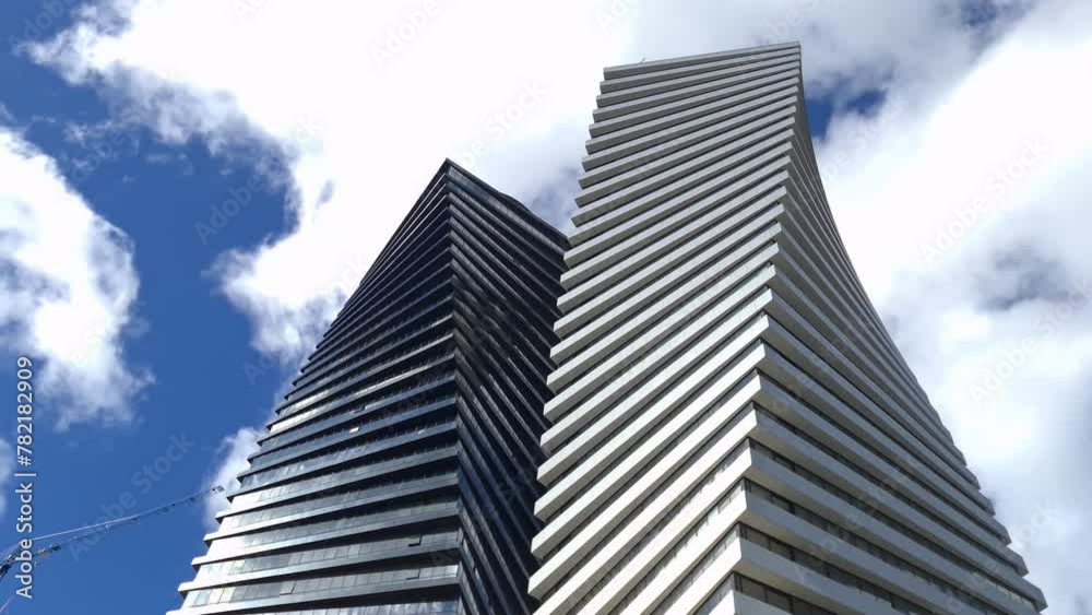 High multi storey skyscrapers unusual irregular shape in city 4k movie. Urban architecture design projects of houses concept